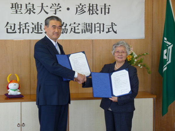 市長と学長の固い握手