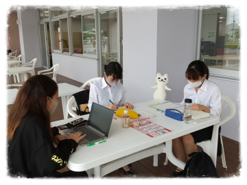 沖縄女子短期大学ウッドデッキで課題に取り組む学生たち