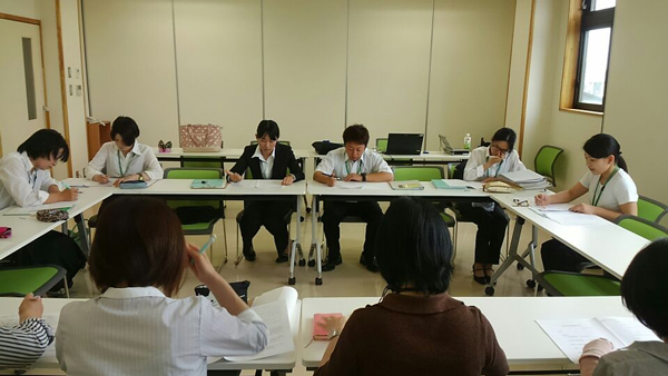 指導者の前で発表する学生